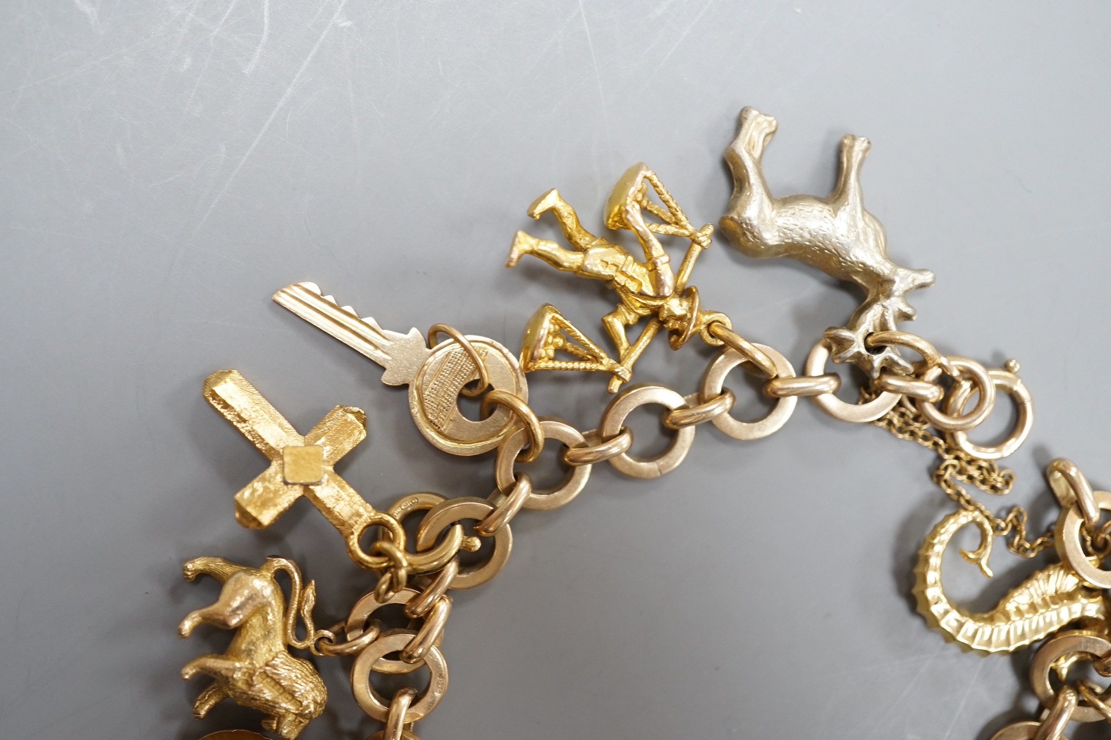 A 9ct gold charm bracelet, hung with assorted charm, including wagon, key, monkey etc. including six 9ct and one 18ct gold, gross weight 33.6 grams.